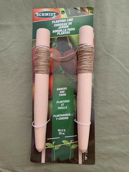 A pair of solid-wood vampire stakes cleverly disguised as garden dibbers with twine. The dibbers are tapered along their length with a pointed end. They will most likely will require some additional sharpening prior to anti-vampire field use.