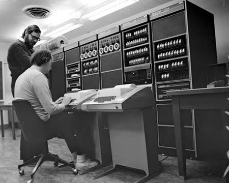 “The first officially named version of Unix ran on the PDP–11/20 in 1970. It is commonly stated that the C programming language took advantage of several low-level PDP–11–dependent programming features, albeit not originally by design”

Two hackers at the DECWriter terminal hammering out a new language. 

source https://en.m.wikipedia.org/wiki/PDP-11