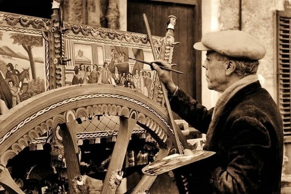 Un Maestro d'arte dipinge le sponde di un carretto siciliano