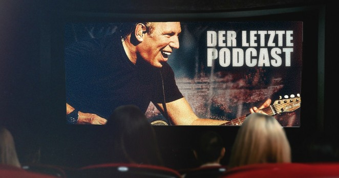 Wir sehen im Kino auf großer Leinwand den deutschen Komponisten Hans Zimmer lächelnd Gitarre spielen. Coverbild von "Der Letzte Podcast" Folge 503.