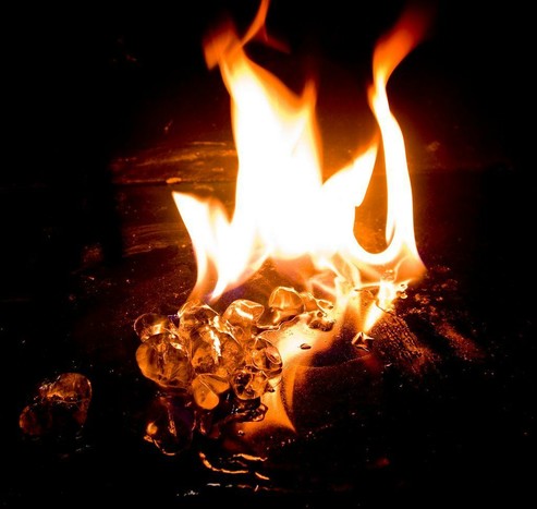 An image of ice cubes melting in the heat of an open fire.