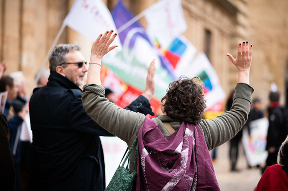 Femme de dos faisant les geste de bras qui accompagne le slogan Siamotutti anti fascisti, elle à un drapeau XR en cap