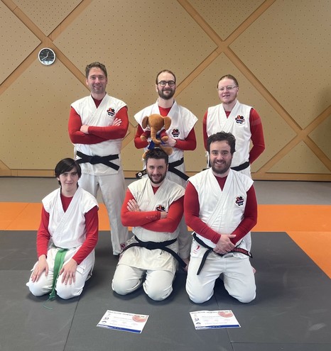 Photo de groupe de l'équipe nantaise en kimono avec des manches rouges. Notre mascotte est un petit éléphant en peluche. Il s'appelle P'tit LU.