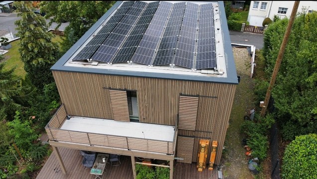 House clad in timber with PV on a flat roof.