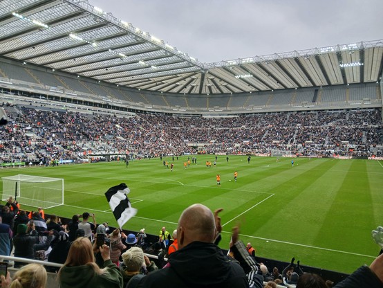 St james park from the gallogate end. It is full except for level 7. On the pitch is Bob Moncur and Darren Eales with the carabao cup