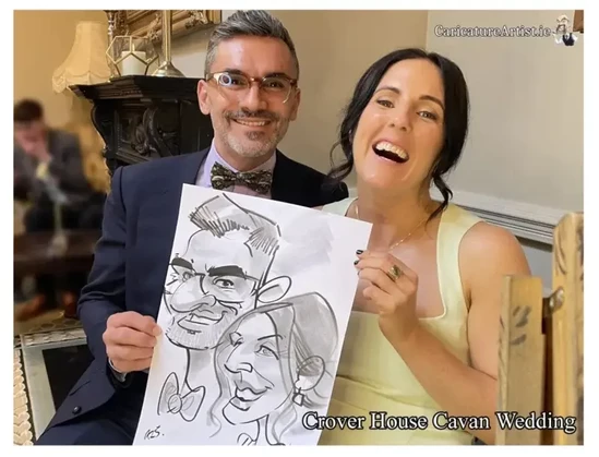A man and a woman at a wedding in Crover House Cavan holding a caricature by Allan Cavanagh