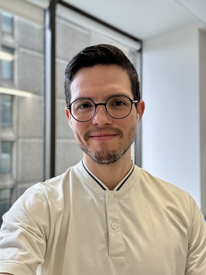 Selfie in the office, wearing a white polo shirt with a band collar.