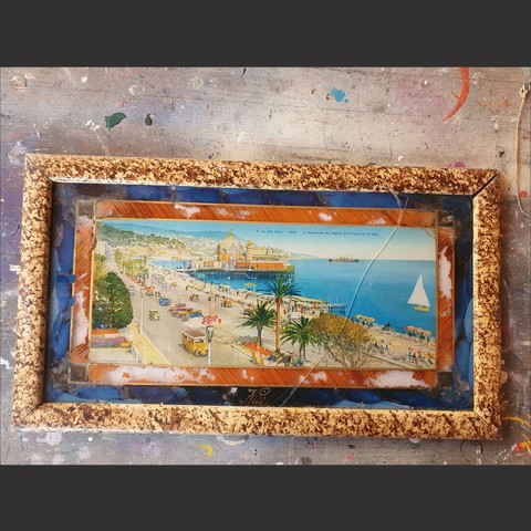 An 1930s souvenir from Nice France featuring a hand coloured print of the Promenade des Anglais in a hand decorated picture frame