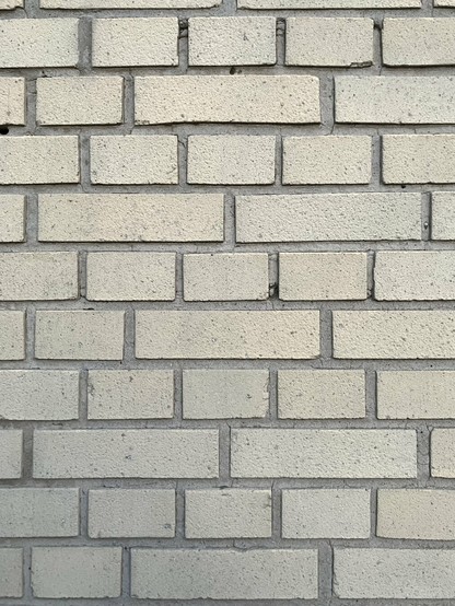 Muur gemetseld in verschillende maten witte bakstenen