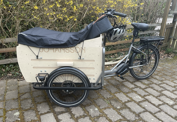 johansson lasten-dreirad mit gitarre die aus der ladtenbox-abdeckung herausragt