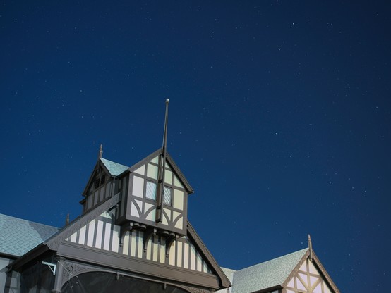 In the foreground is the upper portion of the stage-house of the Elizabethan theater at Oregon Shakespeare Festival. In the background is a clear night sky filled with stars.