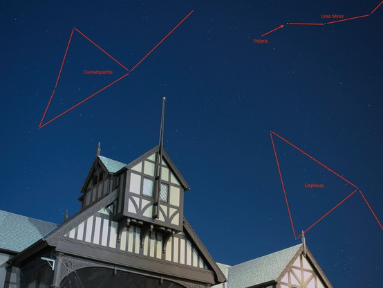 In the foreground is the upper portion of the stage-house of the Elizabethan theater at Oregon Shakespeare Festival. In the background is a clear night sky filled with stars. Constellation outlines are overlaid for Camelopardis, Ursa Minor, and Cepheus