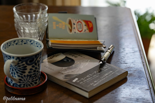 a cup of coffee, stacked glasses, travelersnotebook passport size, book about coffee jelly, fountain pen (brown and white)