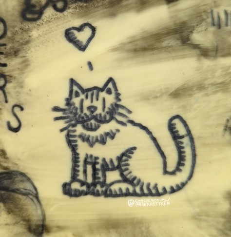 Black tattoo ink on fake skin 

A sitting cat, a heart above it (indicated speech bubble)