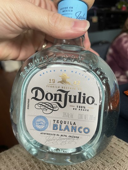 A small round bottle of Don Julio with a blue cap