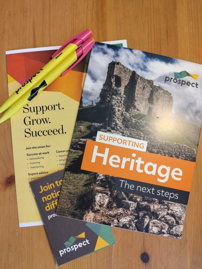 3 leafllets for the Prospect union stacked diagonally over each other with 2 pens in the top left corner. The bottom-most leaflet says "Join today, notice the difference". The right-most says "Supporting Heritage" and the left-most says "Support.Grow. Succeed."