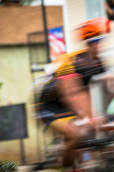 Photograph of a male cyclist participating in the Tour of Utah. The cyclist is moving at speed and the photograph taken so that his image is heavily blurred to emphasize movement.