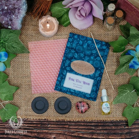 The contents of our exclusive "Pink Full Moon Ritual Kit for the April 12, 2025, Full Moon in Libra" product are arranged on a burlap-covered surface. They include a sheet of pink beeswax and a wick; a pouch of Pink Full Moon herbs, including rose, lavender, and chamomile; a dropper vial of our exclusive Full Moon Spell Oil; a tumbled rhodonite gemstone; and two charcoal discs. Presented by Inked Goddess Creations.