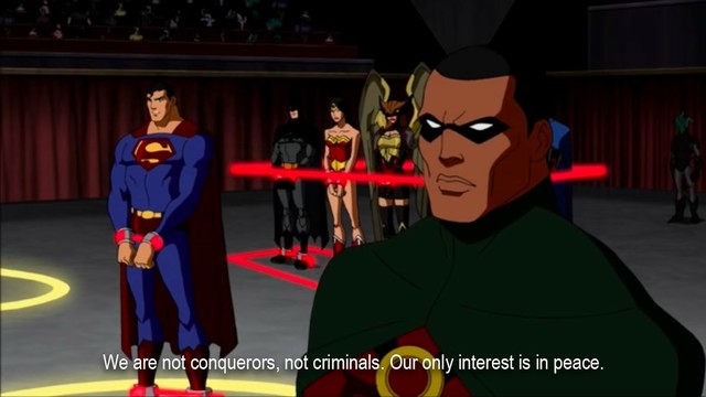 Members of the Justice League, including Batman, Wonder Woman, Superman, and Martian Manhunter, standing in handcuffs in a futuristic trial room dock. The subtitle reads “We are not conquerors, not criminals. Our only interest is in peace.”