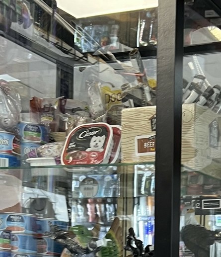 A closer up of a different shelf. There is cat food and tons of dog food visible.