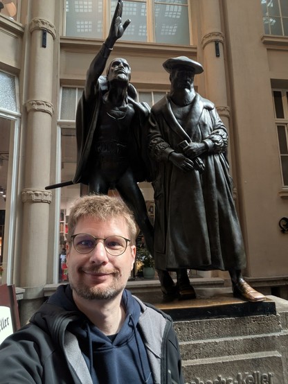 Meine Wenigkeit vor den Statuen von Faust und Mephisto
