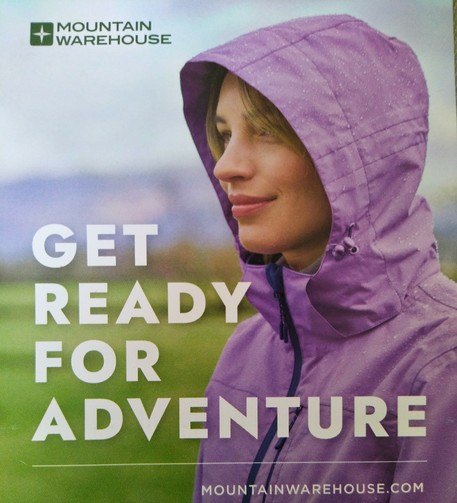 Advert showing a woman in a purple raincoat with the words GET READY FOR ADVENTURE