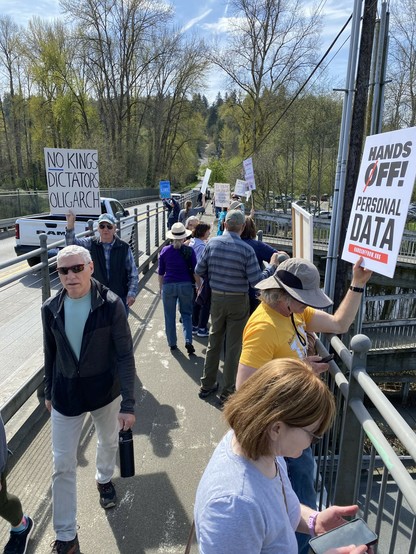 a narrow bridge sidewalk at the far end of bothell downtown filled with protesters