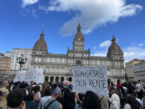 Mani vivenda A Coruña, praza María Pita. Pódese ver a fachada do Concello da Coruña, no primeiro plano hai unha pancarta que di “NIN CASAS SIN XENTE”