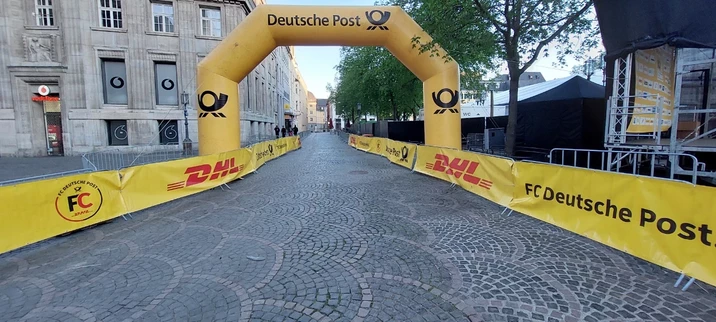 a photograph of the finish area of the Bonn Marathon with a big yellow gate of Deutsche Post