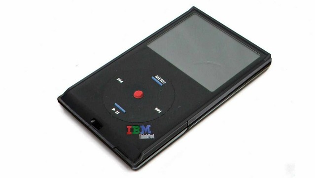 A fake render of an "IBM ThinkPod Classic", which is a parody of an iPod classic but with ThinkPad black plastic case, the clickwheel replaced with directional buttons incl. ThinkVantage blue nubs and a "red dot" trackpoint, next to ThinkPad-esque curvature at the bottom and a "IBM ThinkPod" lettering at the bottom right corner like from a classic ThinkPad