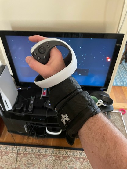 My arm with running weights strapped to it and a PSVR2 controller gripped in my hand