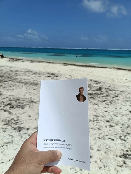 Sosteniendo la edición que Círculo de poesía publicó por el aniversario 150 de su primera publicación. De fondo, la playa y el mar de Puerto Morelos, Quintana Roo.