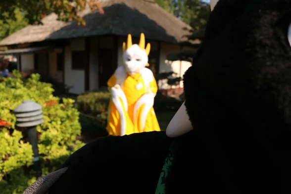 Mostly out of focus image with the black dragon obscuring half of the image and the yellow one standing in the background looking cheekily.