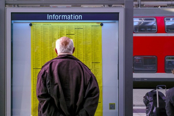 A man peruses the timetable at the station.