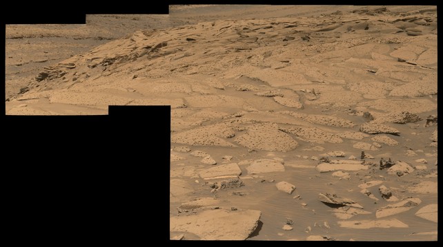 An ochre toned mosaic of a Martian landscape captured by the Mars rover Curiosity.