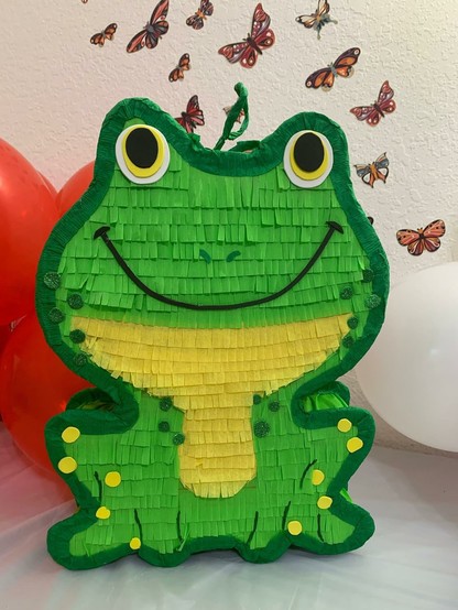 A frog shaped piñata smiling