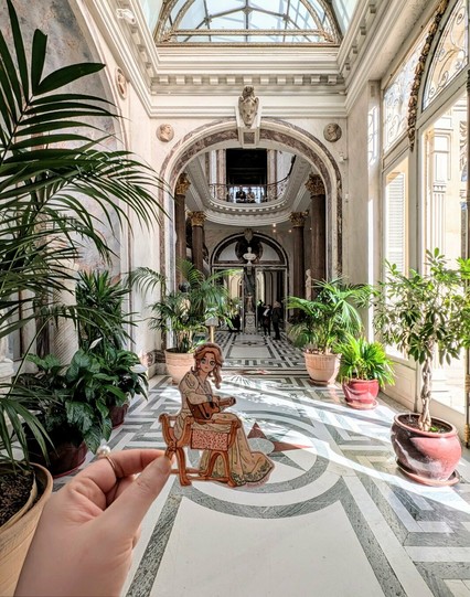 Fanart of Haydée (portrayed by Anamaria Vartolomei), playing a guitar, from the Count of Monte-Cristo, inside the sun-bathed winter garden of Jacquemart-André museum