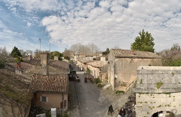 Vue de haut sur une rue de la citadelle. Vieilles pierres et terrasses de restaurants.