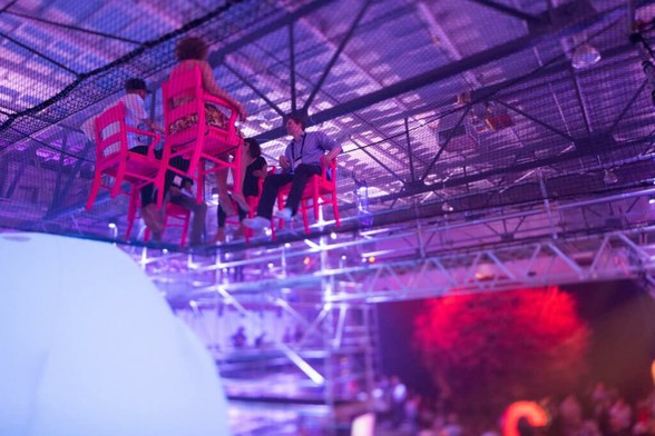 Experiential events that aren't: a photograph of two pairs of people facing each other sitting in chairs suspended from the ceiling