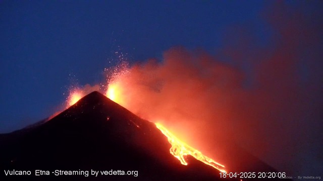 Nel cielo blu serale, si alzano rosse lingue di fuoco e lava provenienti dal vulcano in eruzione