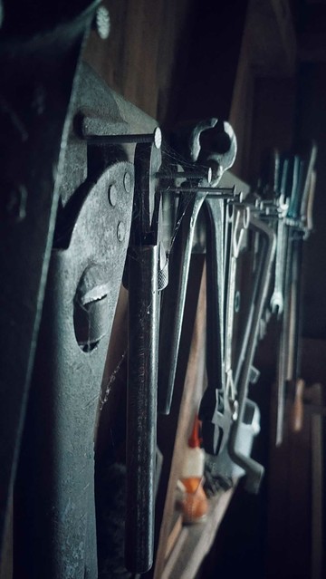 Tools lined up in an old barn.