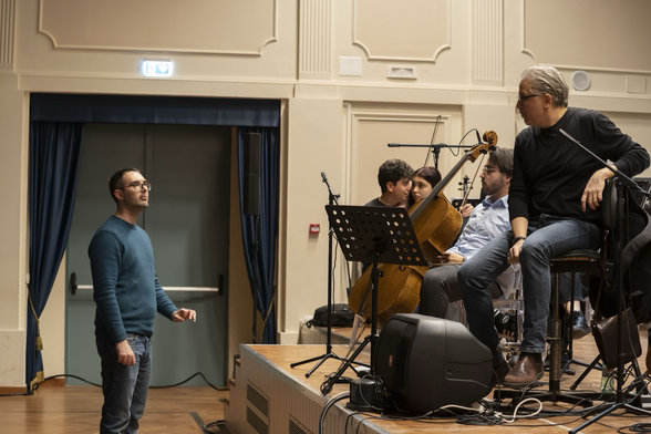 Il compositore Nicola Monopoli discute col direttore d’orchestra Andrea Palmacci durante le prove della sua composizione QFD. Sul palco dell’auditorium del Conservatorio “U. Giordano” l’orchestra d’archi Young e il solista al violoncello Francesco Greco.