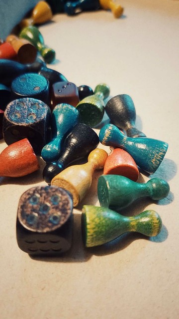 Playing figures, made of wood, in different colours. And two dices.