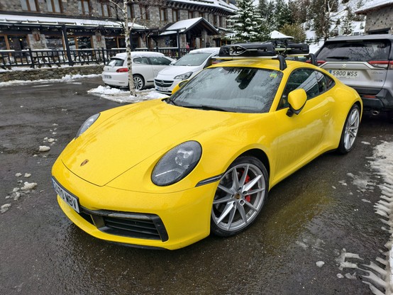Porsche 911 amarillo vista frontal lateral izquierda.