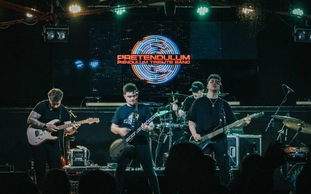 Photo of a live band with four members on stage.