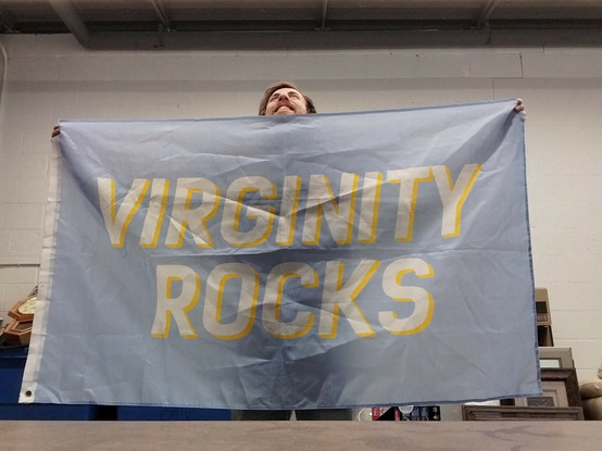 I'm gleefully holding a full-size flag that reads "VIRGINITY ROCKS"