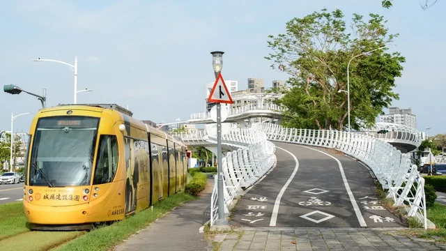 A view of the entrance to the Cianjhen Star Bridge (for walking and rolling) with a yellow LRT on the left.