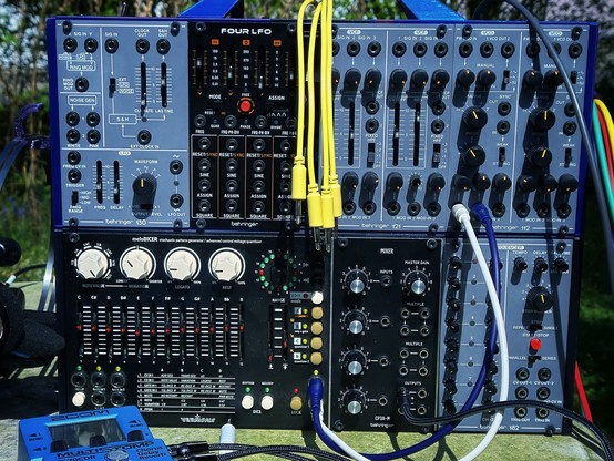 Science station report… the blue 3D-printed Eurorack is loaded for deep subspace CV analysis. Modules include the Behringer 150 (with ring mod, noise, and S&H), the quad-function Four LFO, and dual 121 VCFs… ready to sculpt signals like a Vulcan engineer sculpts logic. A Behringer 112 dual VCO  and 182 sequencer manage frequency and time. The Vermona Melodicer generates stochastic patterns with precision, while a CP3A-M mixer provides audio subrouting. A vivid blue Zoom MS-70CDR floats below… set for reverb-based modulation. On the far left, a legendary Koss PortaPro headset clings to the case… classic Earth tech, still unmatched for audio reconnaissance.