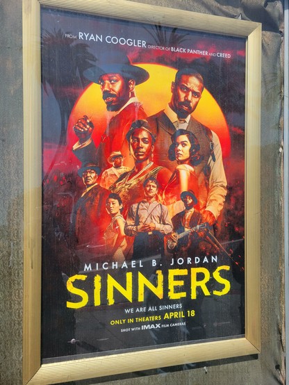 Promotional movie poster for Sinners. The title appears in yellow block letters at center-bottom. A collage of actors appears at center, behind an orange-red sun at the horizon. Actors shown include Michael B. Jordan (shown twice), Hailee Steinfeld, Miles Caton, Jack O'Connell, Wunmi Mosaku, Jayme Lawson, Omar Miller, Li Jun Li, Buddy Guy, and Delroy Lindo