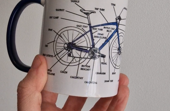 Una taza de café pintada con el crokis de una bicicleta
